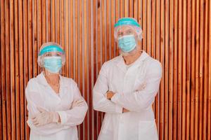 medici con maschera e viso protettore siamo pronto per opera nel ospedale foto