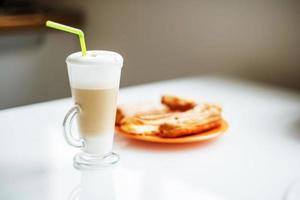 un' tazza di latte macchiato su il tavolo. mattina caffè con torte. prima colazione foto