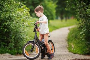 il ragazzo è equitazione un' bicicletta su il strada foto