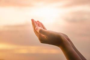 mani unite come pregare davanti allo sfondo della natura foto