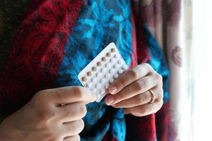 donna che tiene la pillola anticoncezionale foto
