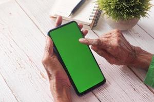 persona che utilizza smart phone con schermo verde foto
