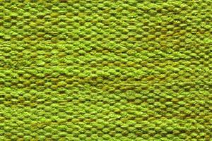 intrecciata verde lana tessuto struttura. mano a maglia tessile tela sfondo. patchwork tappeto sfondo. fabbrica Materiale fili. astratto design. avvicinamento, modello, superiore Visualizza foto