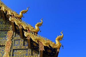 giusto tetto decorato con naga testa ann linea strutturato nel tailandese stile con chiaro blu cielo a wat rong sua dieci, chiang rai, Tailandia. buddista tempio, esterno struttura design con copia spazio. foto