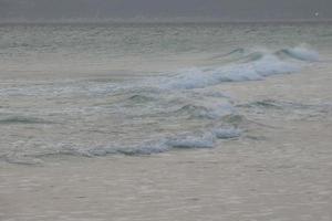 solitario, poco affollato spiaggia con calma mare e piccolo onde foto