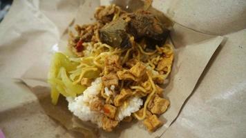 nasi kucing speciale, gatto riso speciale con opor hati sapi su un' carta avvolgere foto