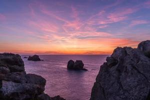 tramonto sulla spiaggia rocciosa foto