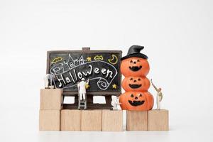 persone in miniatura che colorano le decorazioni del puntello del partito di Halloween su una priorità bassa bianca, concetto del partito di Halloween foto