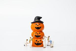 persone in miniatura che colorano le decorazioni del puntello del partito di Halloween su una priorità bassa bianca, concetto del partito di Halloween foto