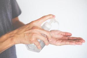 mani dell'uomo utilizzando il dispenser di gel disinfettante per le mani contro il nuovo coronavirus o covid-19, concetto di igiene e sanità foto