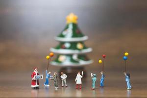 famiglia felice in miniatura che celebra il concetto di natale, natale e felice anno nuovo foto