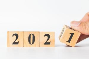 mano che lancia un cubo di legno con il numero dal 2020 al 2021, concetto di felice anno nuovo foto