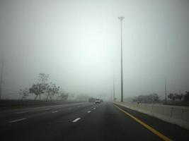 strada nel il nebbia, cartello citare mantenere distanza per autostrada-t7.svg foto