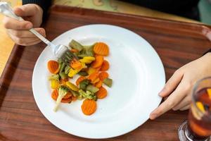 salutare salutare cibo su un' vassoio nel un' piatto. mangiare verdure con un' forchetta foto