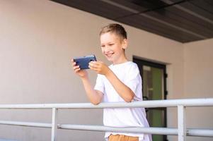 un' ragazzo è in piedi su il strada con un' Telefono foto