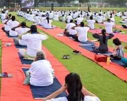 nuovo delhi, India, giugno 21 2022 - gruppo yoga esercizio sessione per persone a yamuna gli sport complesso nel delhi su internazionale yoga giorno, grande gruppo di adulti frequentando yoga classe nel cricket stadio foto