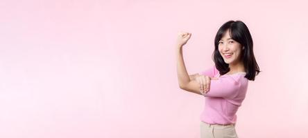 ritratto giovane asiatico donna orgoglioso e fiducioso mostrando forte muscolo forza braccia flesso in posa, si sente di sua successo risultato. donne Potenziamento, uguaglianza, salutare forza e coraggio concetto foto