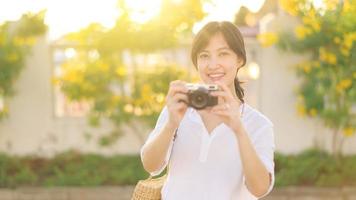 ritratto di asiatico donna viaggiatore utilizzando telecamera a strada di bangkok, Tailandia. Asia estate turismo vacanza concetto foto