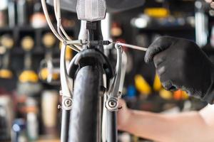 tecnico fa aggiustamenti per freno su un' pieghevole bicicletta Lavorando nel laboratorio , bicicletta riparazione e Manutenzione concetto foto