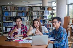 asiatico Università studenti leggere libri e studia insieme nel il biblioteca. foto