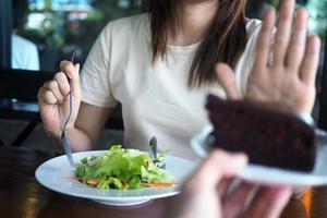 uno donna è controllo il peso. torta su e scegliere per mangiare verdura intagli. foto