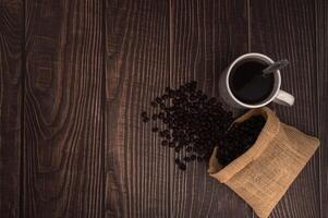 tazza di caffè con chicchi di caffè su un tavolo di legno foto