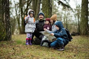 famiglia e bambini con carta geografica nel il foresta. foto