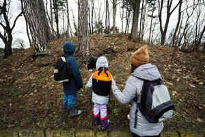 madre e bambini a piedi nel foresta, si accorse un animale tana. foto