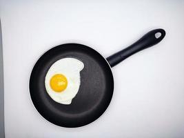 soleggiato lato su uova su un' nero padella isolato nel bianca sfondo foto
