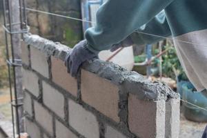 selettivo messa a fuoco su mattoni essere installato di costruttori, concetto foto di il processi di edificio un' Casa, magazzino. morbido messa a fuoco