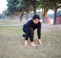 giovane indiano donna praticante yoga all'aperto nel un' parco. bellissimo ragazza pratica di base yoga posa. quiete e relax, femmina felicità. di base yoga pose all'aperto foto