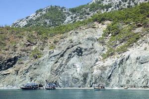 grigio sabbia spiaggia con turista Barche foto