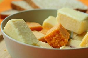 formaggio cubi verde, giallo e rosso colore su chopping tavola foto