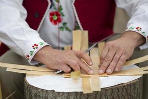 mani di il maestro rendere prodotti a partire dal betulla abbaio. tessitura un' cestino. etnico slavo artigianato. foto