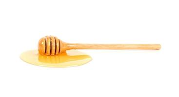 miele con miele mestolo su bianca sfondo foto