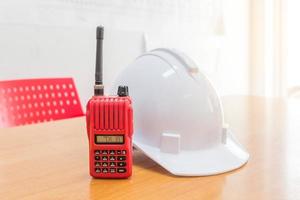 radio walkie-talkie rossa e un elmetto di sicurezza bianco foto