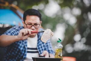 ritratto di asiatico viaggiatore uomo bicchieri Maiale bistecca frittura foto