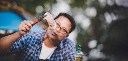 ritratto di asiatico viaggiatore uomo bicchieri Maiale bistecca frittura foto