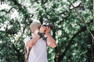 asiatico viaggiatore uomo con zaino assunzione un' foto nel il parco