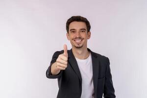 ritratto di contento sorridente giovane uomo d'affari mostrando pollici su gesto su isolato al di sopra di bianca sfondo foto