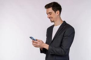 ritratto di un' contento uomo d'affari utilizzando smartphone al di sopra di bianca sfondo foto