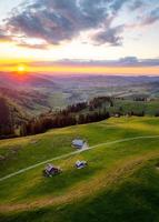 un' azienda agricola alto su il colline durante un' tramonto nel il distanza voi può vedere un' collinoso paesaggio foto