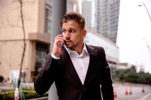 ritratto di un' giovane uomo d'affari nel un' attività commerciale centro parlando su il Telefono foto