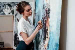 il artista vernici astratto olio quadri, Lavorando su un' pittura nel un' accogliente studio foto