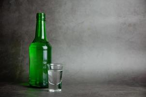 soju con bicchiere su grigio sfondo, selettivo messa a fuoco foto