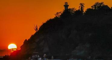 colorato d'oro tramonto grande onda rocce spiaggia puerto escondido Messico. foto