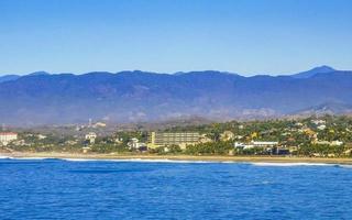 sole spiaggia scogliere rocce onde palme montagne puerto escondido Messico. foto