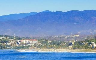 sole spiaggia scogliere rocce onde palme montagne puerto escondido Messico. foto