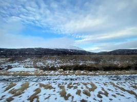 islandese inverno paesaggio con neve coperto colline e blu nuvoloso cielo foto