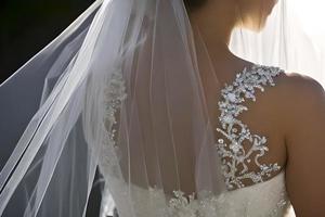 vicino su dettaglio un' sposa a partire dal dietro a nel un' bianca nozze vestire. foto